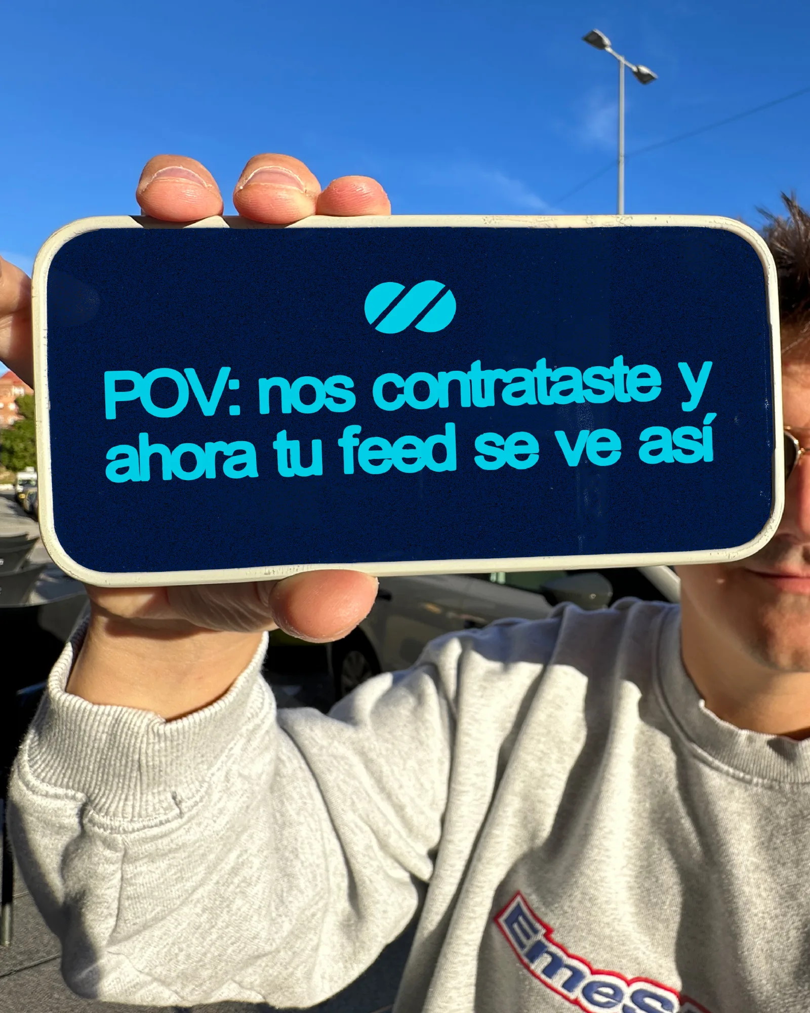 Persona sujetando un móvil con el logo de Impulsa8 y el texto «POV nos contrataste y ahora tu feed se ve así»